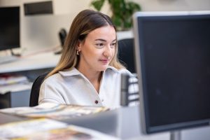 A picture of a Newtrade employee working at her desk